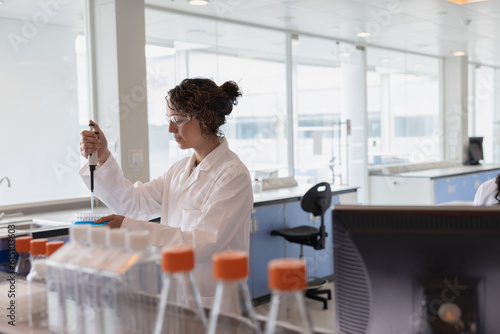 Scientist using a pipette in a pharmaceutical laboratory photo