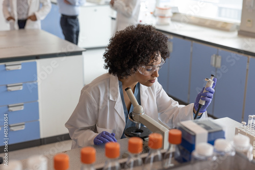 Female scientist pipetting in laboratory  photo