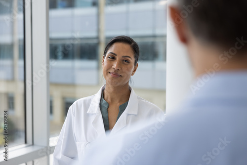 Happy and confident female Doctor in Hospital talking with a coworker photo