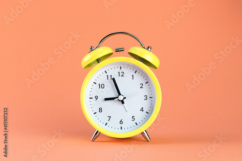 Foto Yellow alarm clock on a colored orange background
