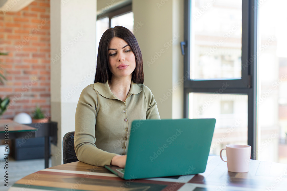 pretty young woman smiling and looking with a happy confident expression. laptop and desk concept pretty young woman smiling and looking with a happy confident expression. laptop and desk concept