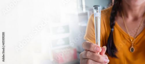 Joint of a cigarette with marijuana in a plastic package in a close-up in a woman's hand, a concept with an empty white background for the copy space text.