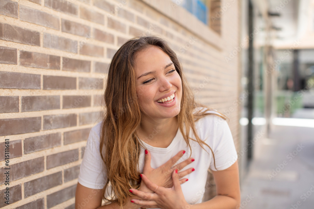 pretty hispanic woman laughing out loud at some hilarious joke, feeling happy and cheerful, having fun