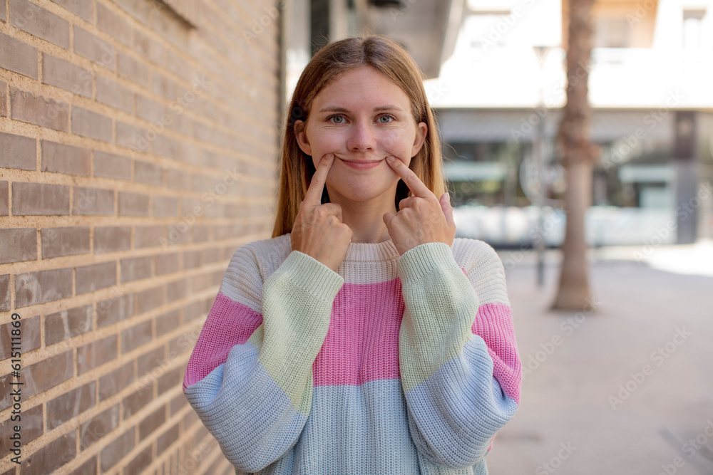 pretty young woman smiling confidently pointing to own fake smile pretty young woman smiling confidently pointing to own fake smile