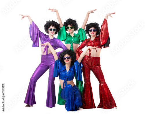 A group of girls in colorful flared suits and afro wigs pose against a white background. Disco style from the eighties or seventies.