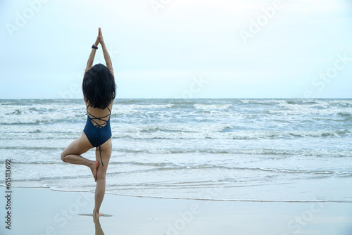 Beautiful healthy woman doing morning yoga on the beach,Thailand photo