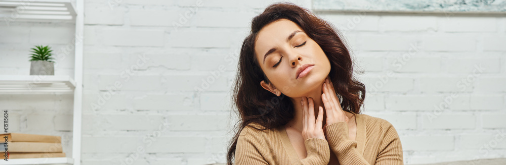 Brunette woman in casual jumper massaging lymphatic nodes on neck during self-massage and wellness routine at home, self-care ritual and holistic wellness practices concept, banner, tension relief Brunette woman in casual jumper massaging lymphatic nodes on neck during self-massage and wellness routine at home, self-care ritual and holistic wellness practices concept, banner, tension relief