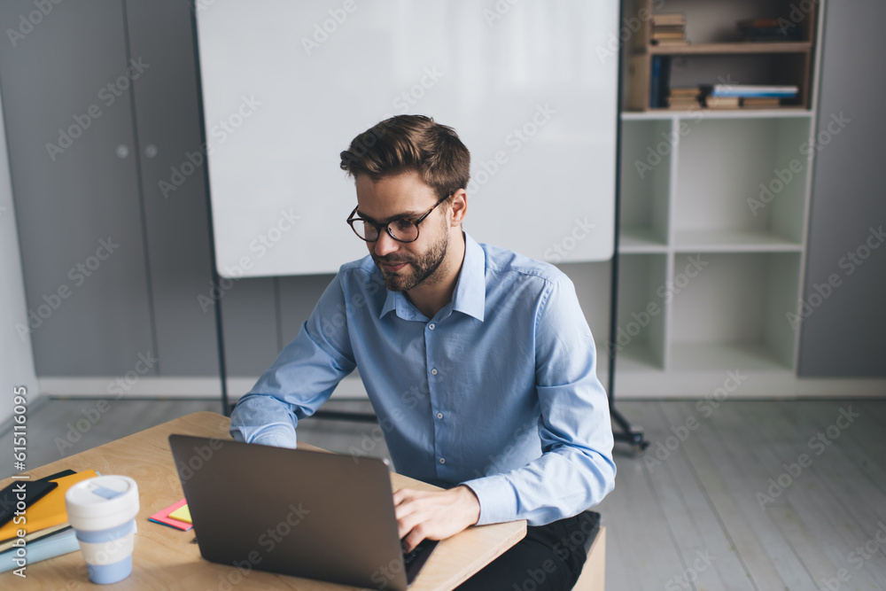 Millennial businessman working on laptop in office Millennial businessman working on laptop in office