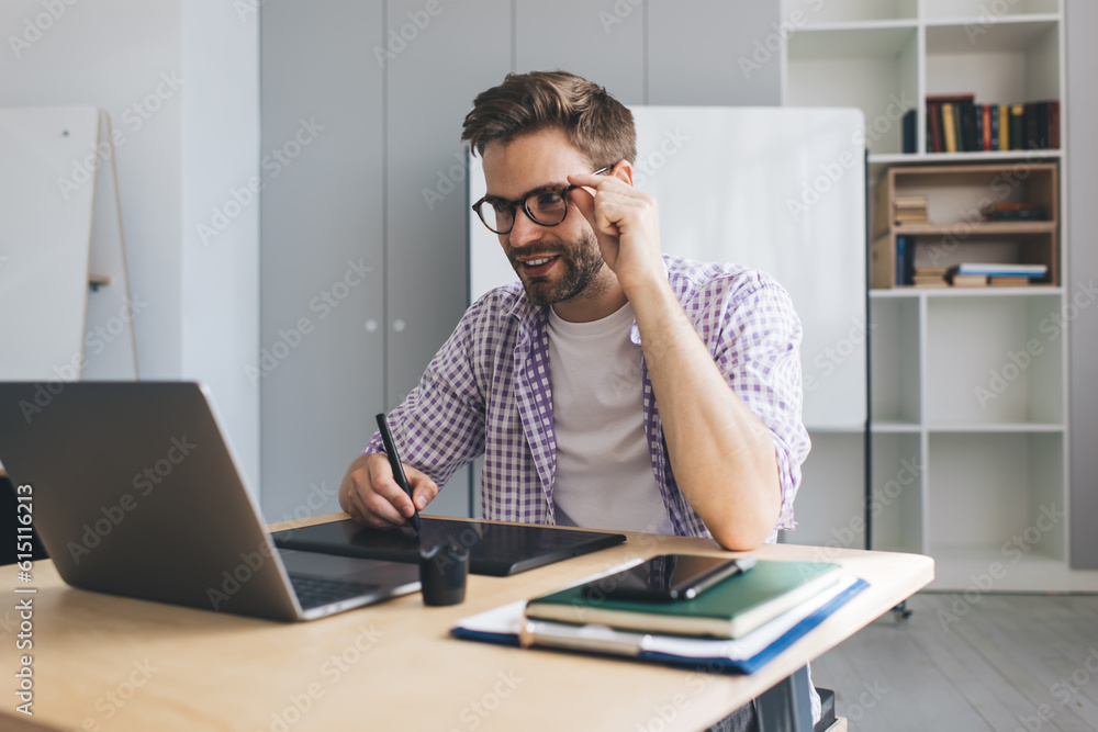 Millennial businessman working at desk in office Millennial businessman working at desk in office