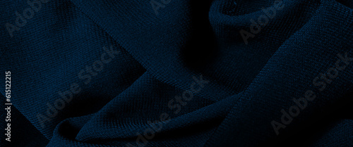 Dark blue silk fabric background, view from above. Smooth elegant blue silk or satin luxury cloth texture, blue chiffon fabric draped with large folds, wave textile background