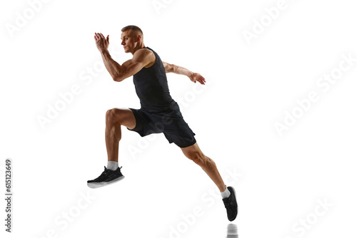 Dynamic image of young man with muscular, strong, fit body, professional runner in motion against white studio background