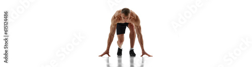 Ready, steady, go. Muscular man, professional runner standing in position to start running over white background.