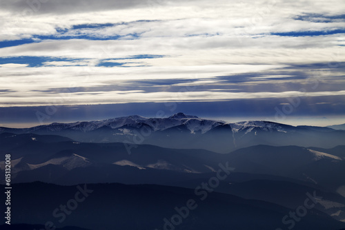 Silhouettes of cloudy mountains in evening