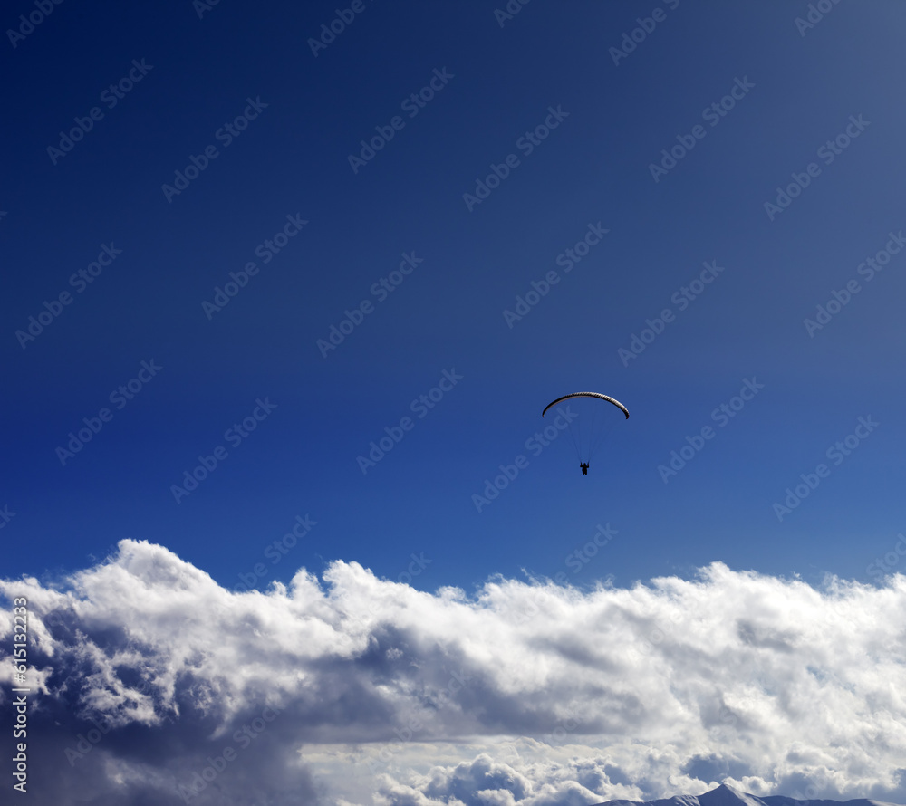 Silhouette of paraglider and blue sunny sky Silhouette of paraglider and blue sunny sky