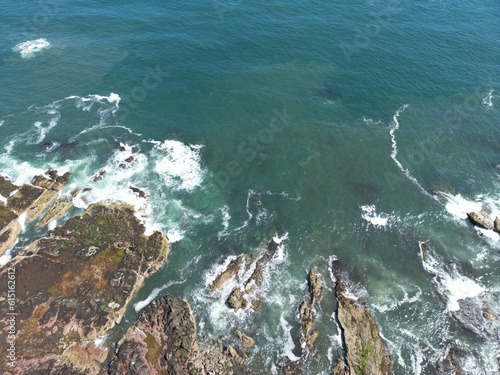 Aerial top down view of waves crashing onto the rocks off the coastline of Dunbar Scotland. 