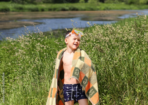 a boy in summer on the riverbank in underwater glasses