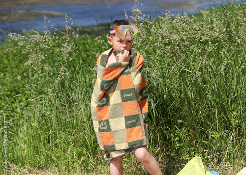 a boy in summer on the riverbank in underwater glasses