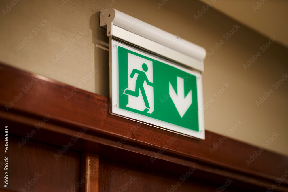 Exit icon, close-up. Direction to the emergency exit. a green light sign indicating the direction of movement to the emergency exit in the room. green emergency exit sign above a door in a interior. Exit icon, close-up. Direction to the emergency exit. a green light sign indicating the direction of movement to the emergency exit in the room. green emergency exit sign above a door in a interior.