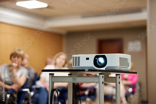 Screen projector. the projector is showing video. digital video projector on a stand, rear view. video projector at a business conference, seminar or lecture in the office, on a stand.