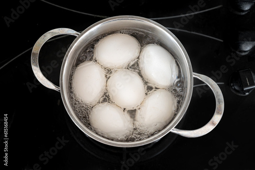 Photos Chicken eggs are boiled in a steel pot on the built-in cooker