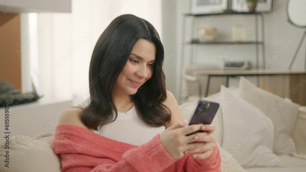 Happy hispanic girl holding cell phone. Latino female using smartphone device at home. Smiling young latin woman blogger posting on social media, buying on internet, ordering products online in app 4K Happy hispanic girl holding cell phone. Latino female using smartphone device at home. Smiling young latin woman blogger posting on social media, buying on internet, ordering products online in app 4K