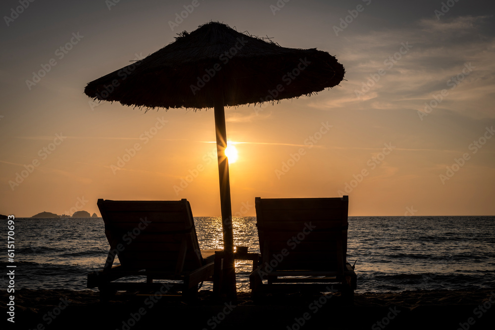 Sun loungers and parasol in sunset on Paros island, Greece