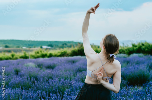 Fototapeta Naklejka Na Ścianę i Meble -  Woman doing peaceful warrior yoga pose with ok sign in rural lavender field