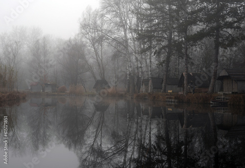 Landscape of a beautiful fishing lake. Winter morning, a mist on the lake.