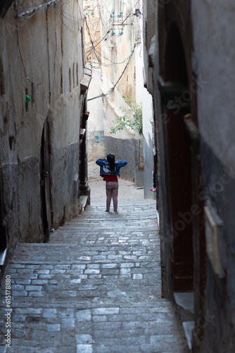 Algiers (Alger), Algeria : Street scene in the Casbah. Stone stairs and ancient ottoman houses. Little girl walking. Chiaroscuro atmosphere. © Bruno