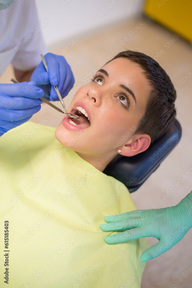 Young woman checking her teeth at the dentist clinic Young woman checking her teeth at the dentist clinic