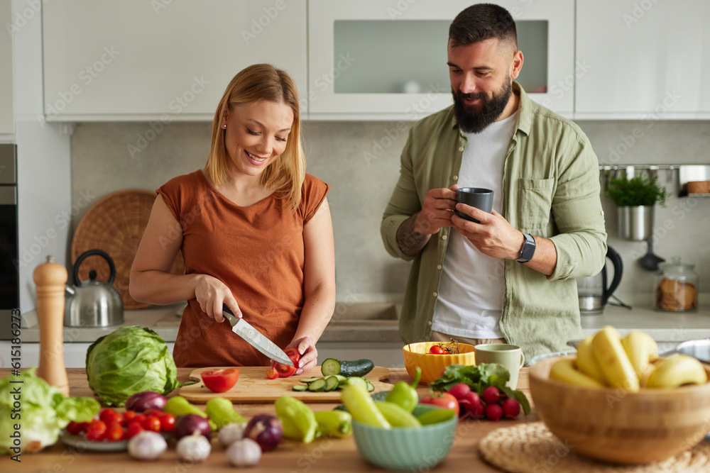 Affectionate couple cutting vegetable in the kitchen