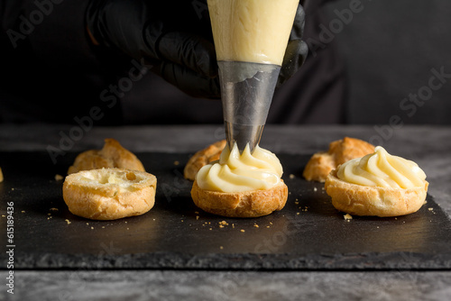 A confectionery sleeve is used to fill profiteroles with cream