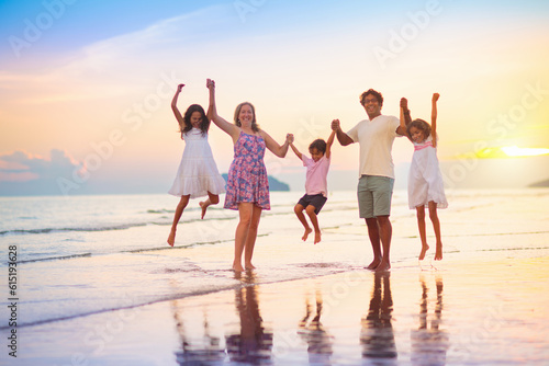 Family walking on tropical beach at sunset