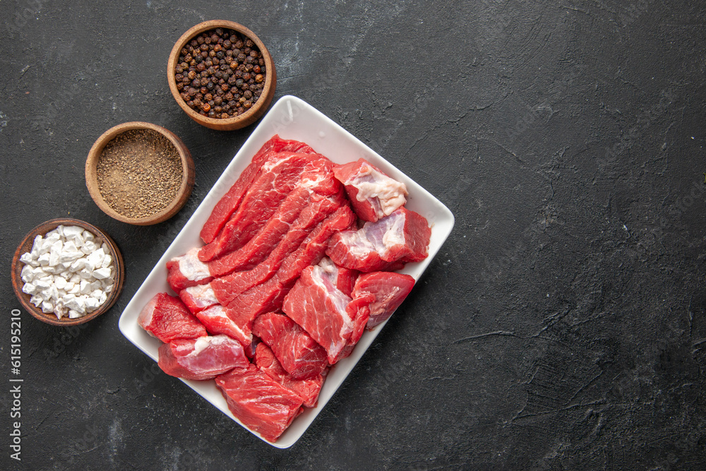 top view fresh sliced meat with seasonings on a dark background meat butcher barbecue meal dinner animal food top view fresh sliced meat with seasonings on a dark background meat butcher barbecue meal dinner animal food