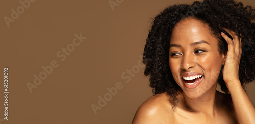 beautiful young black woman laughing on brown, copy space
