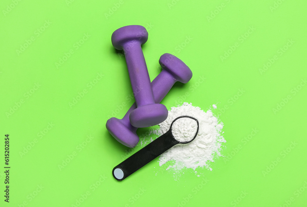 Scoop of amino acid supplement and dumbbells on color background Scoop of amino acid supplement and dumbbells on color background