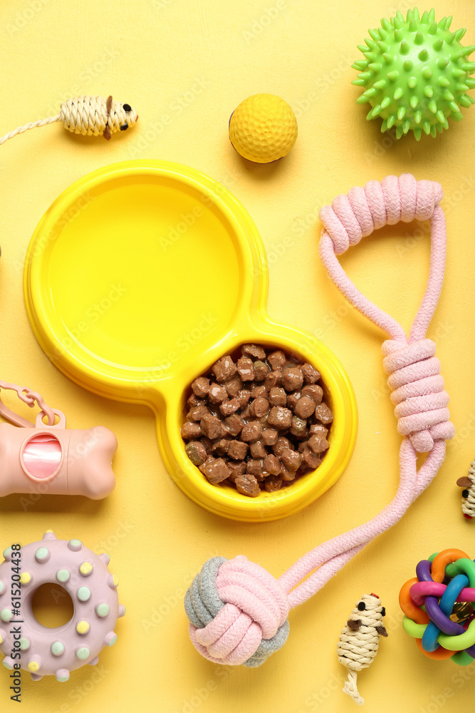 Obraz premium Composition with bowl of wet food and pet care accessories on yellow background