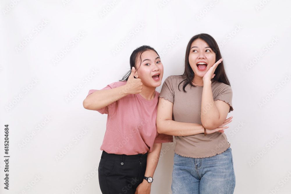 Fototapeta premium Two exciting cheerful asian women standing while shouting. Isolated on white