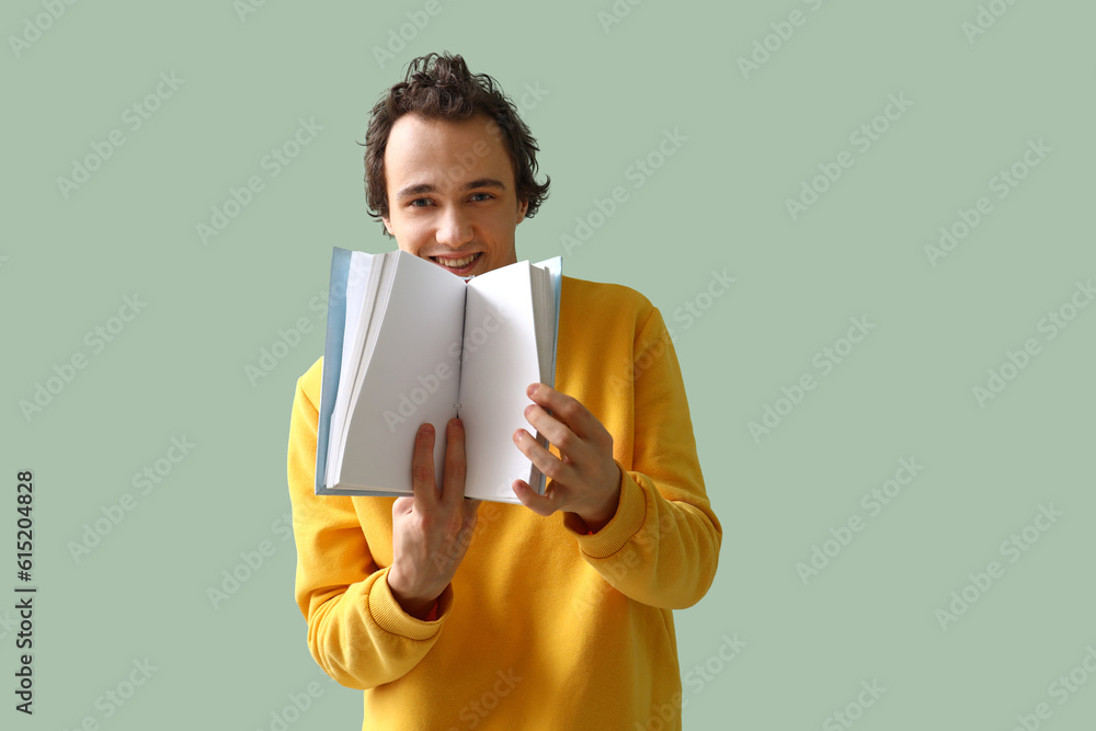 Young man with open book on green background Young man with open book on green background