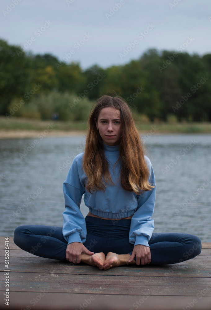 View of a girl in Lotus Pose near lake in rainy weather