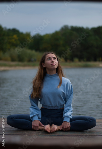 View on a girl in Lotus Pose near lake