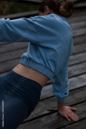 View on aestetic body of a girl in blue gym suit in the park