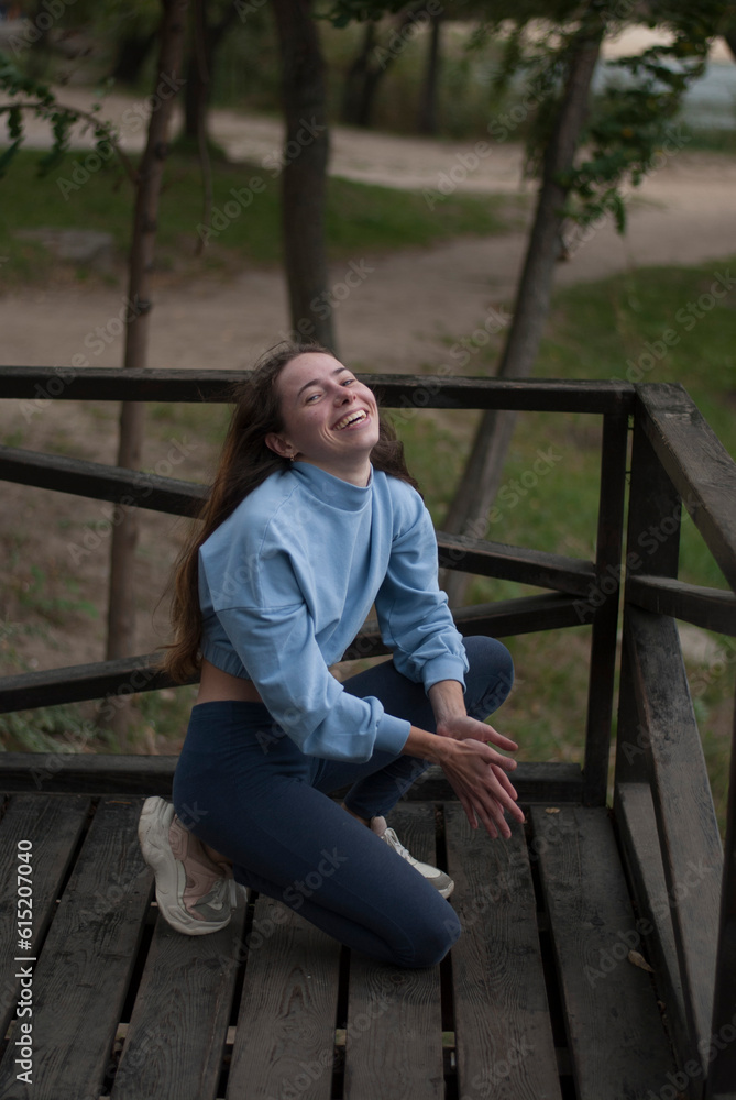 Obraz premium View on a girl smilling while doing acrobatics exercises in cloudy weather