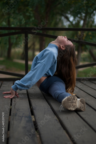 View of a girl is doing split in the park.