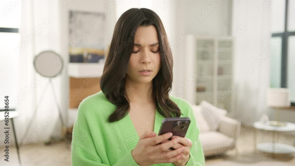 Worried free lance entrepreneur manager using mobile phone. Digital technology applications for small business development 4K slow. Young businesswoman holding smartphone standing in home office Worried free lance entrepreneur manager using mobile phone. Digital technology applications for small business development 4K slow. Young businesswoman holding smartphone standing in home office