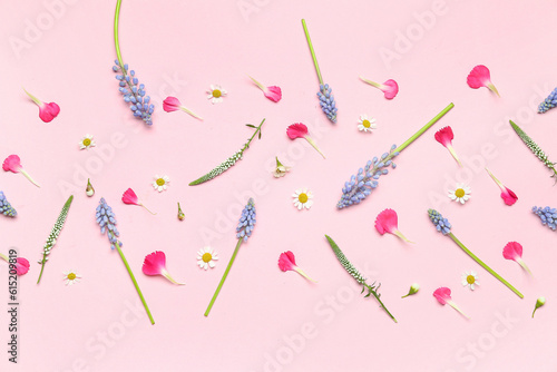 Composition with beautiful Muscari flowers and petals on pink background