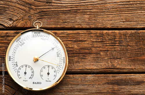 Aneroid barometer on brown wooden background