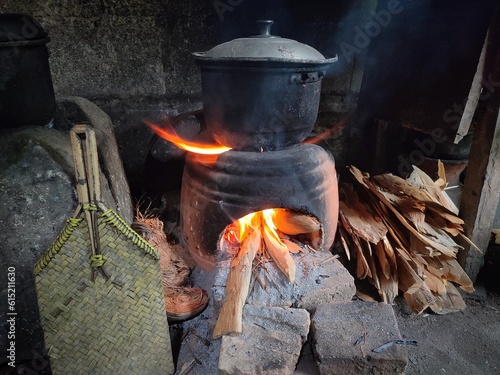 Fotografi Cooking on a clay stove or earthenware stove, with a wood fire, traditional kitc