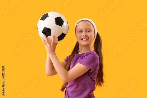 Sporty little girl with soccer ball on yellow background © Pixel-Shot