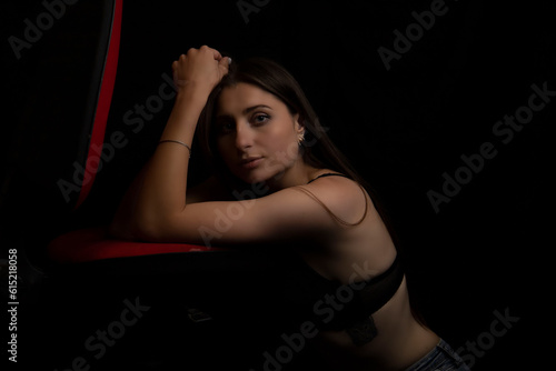 Beautiful young girl in a white shirt and jeans on a black background